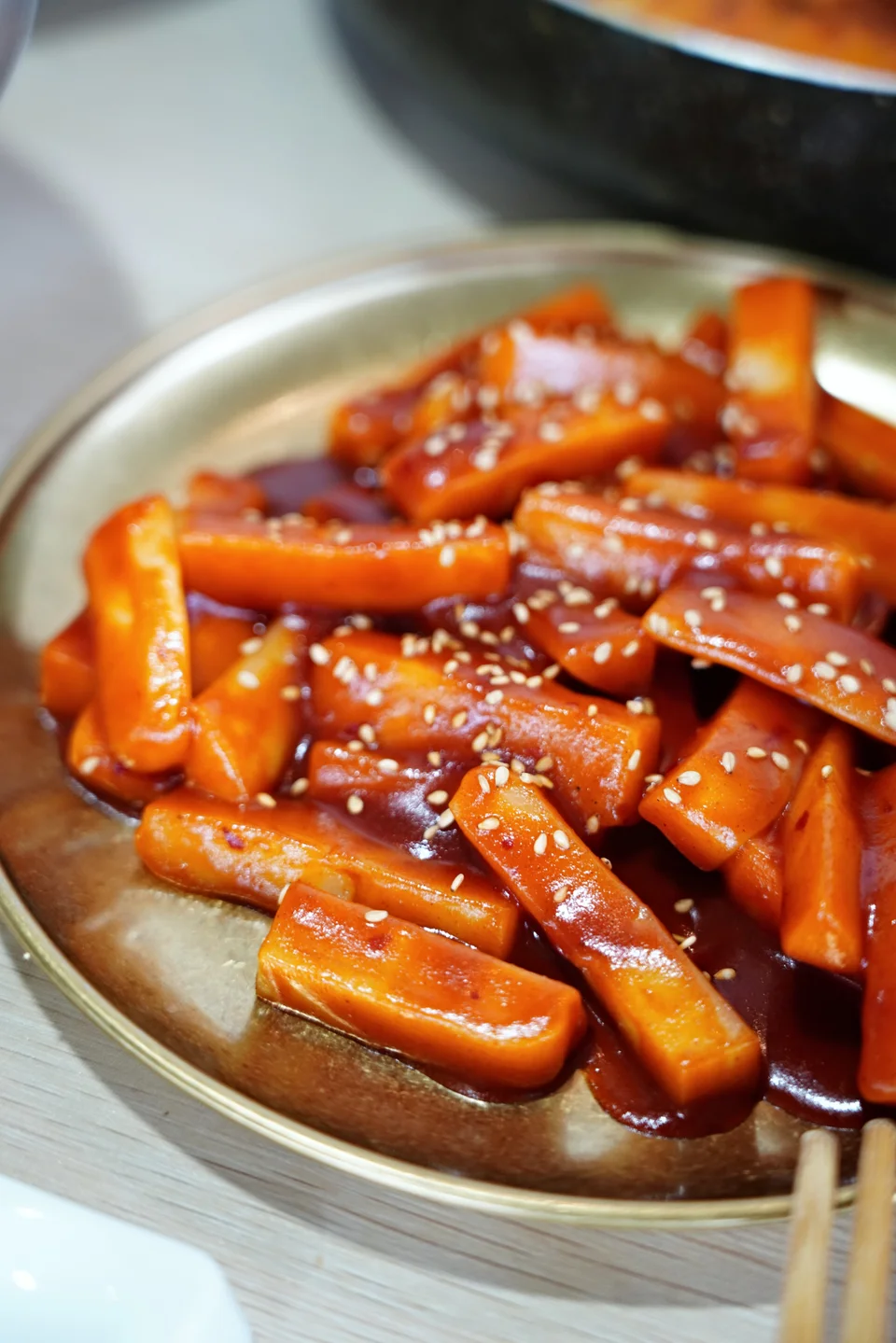 Rice cakes coated in sauce and served on a plate