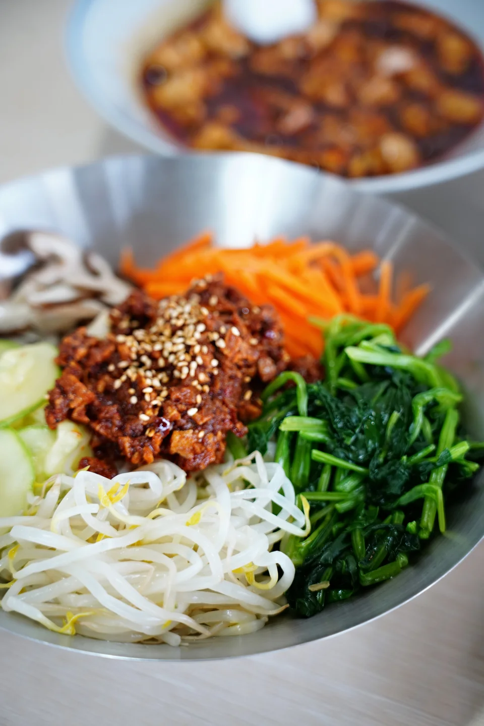A bowl of vegetables served with a sauce topping